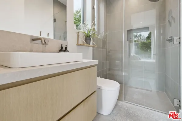 a bathroom with a sink a toilet and shower