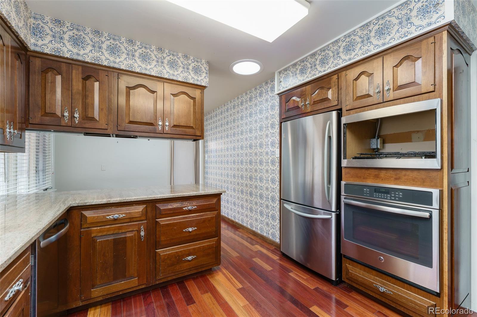 4184 Everett Drive Wheat Ridge, CO 80033 - Photo 11 of 22 a kitchen with stainless steel appliances granite countertop a refrigerator and a stove top oven