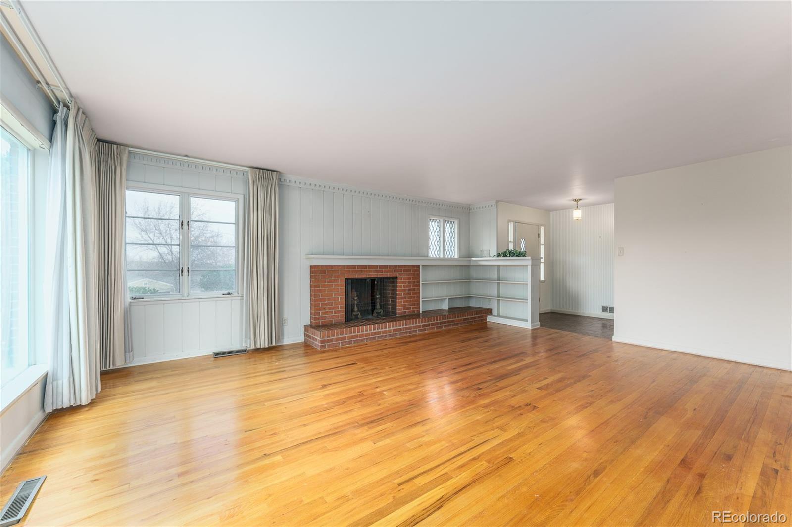4184 Everett Drive Wheat Ridge, CO 80033 - Photo 6 of 22 a view of empty room with wooden floor and fireplace