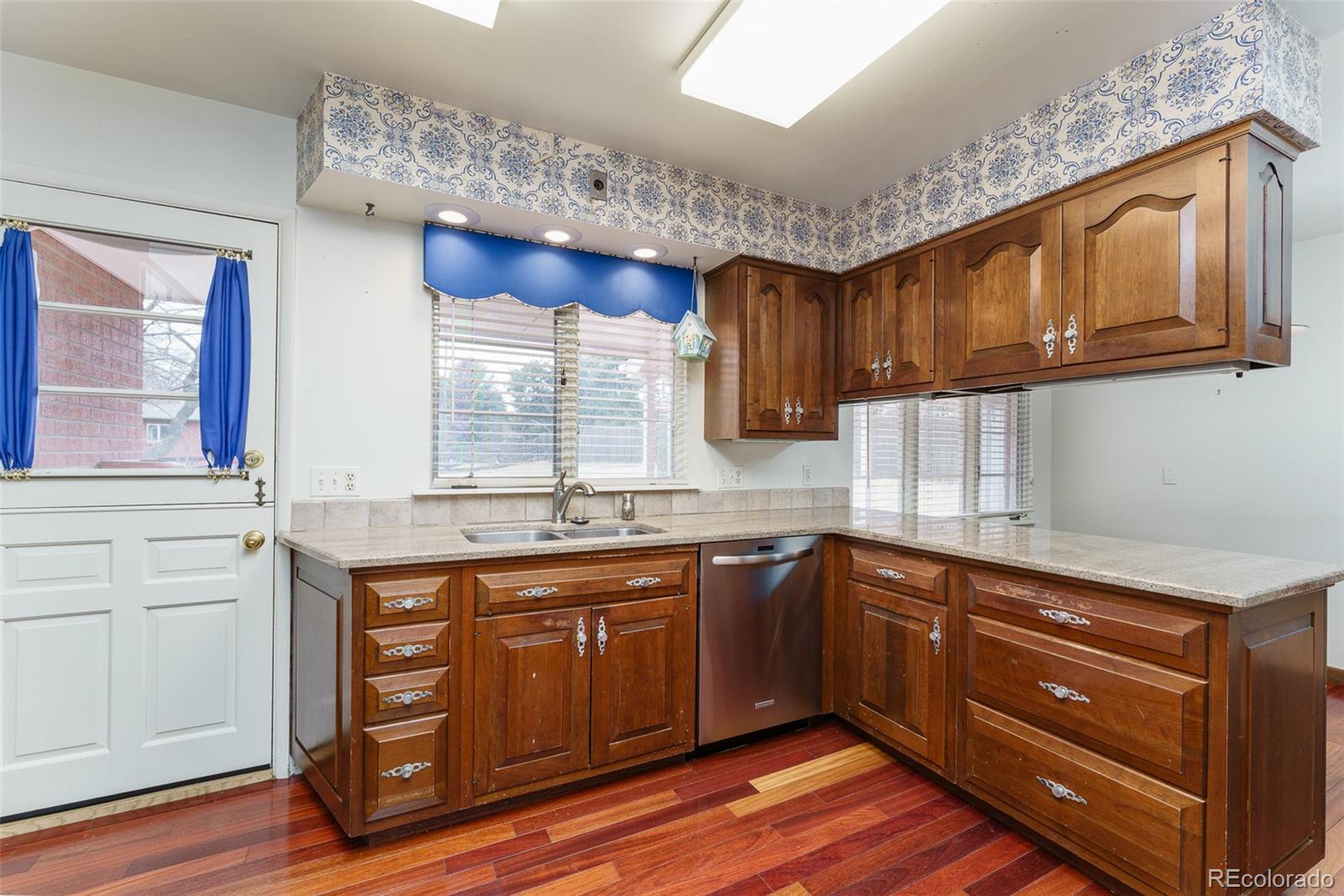 4184 Everett Drive Wheat Ridge, CO 80033 - Photo 9 of 22 a kitchen with stainless steel appliances granite countertop wooden cabinets a sink and dishwasher with wooden floor