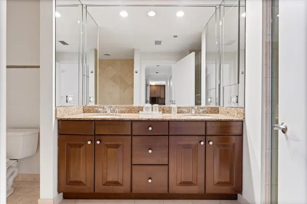 a bathroom with a shower sink double vanity and mirror