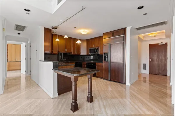 a kitchen with stainless steel appliances granite countertop a refrigerator and a sink