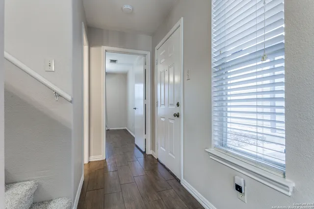 a view of a hallway with wooden floor and windows