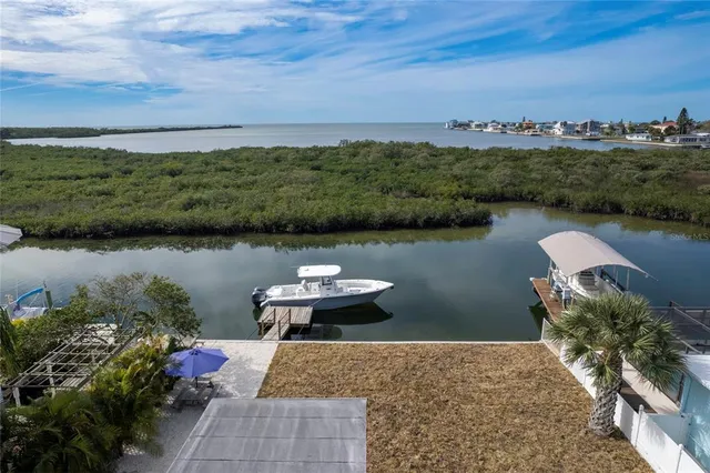 an aerial view of a house with a yard and lake view