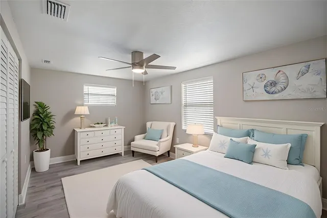an empty room with wooden floor and ceiling fan