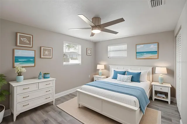 an empty room with wooden floor closet and fan