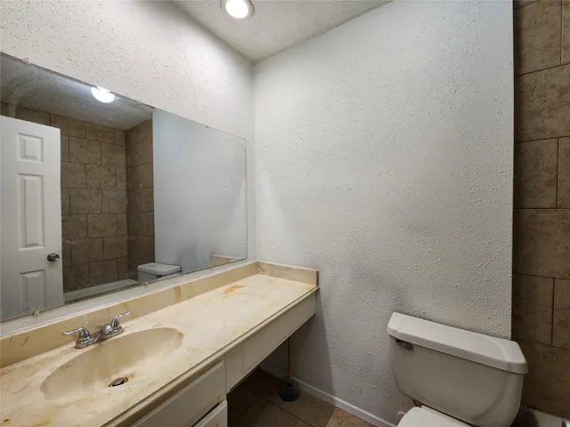 a bathroom with a toilet sink and mirror