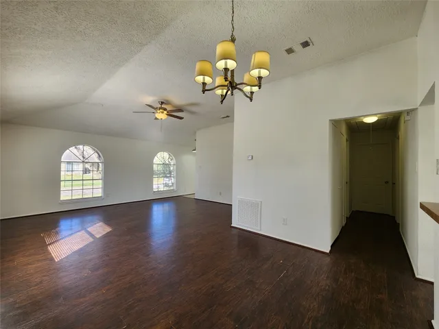 a view of a room with wooden floor and chandelier
