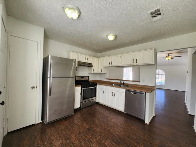 a kitchen with granite countertop a refrigerator and a sink