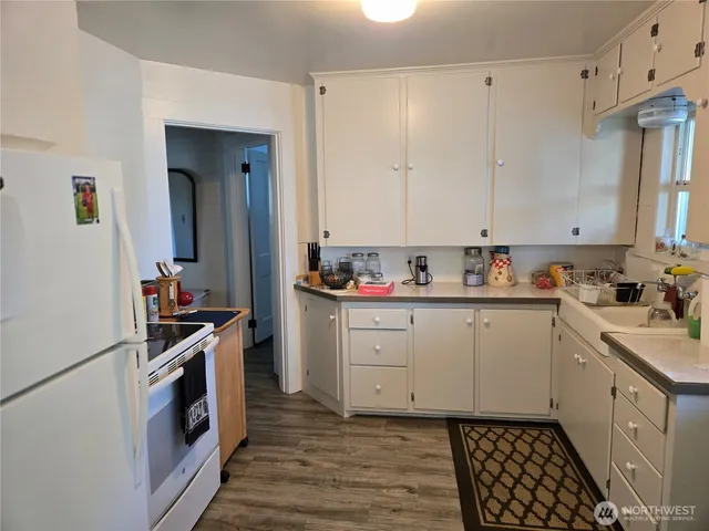 a view of a hallway with wooden floor and closet