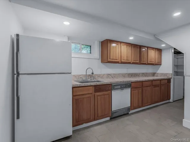 a kitchen with granite countertop a sink and a refrigerator