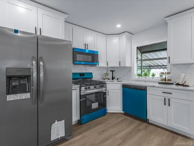 a kitchen with stainless steel appliances granite countertop a stove a refrigerator and a sink with wooden cabinets