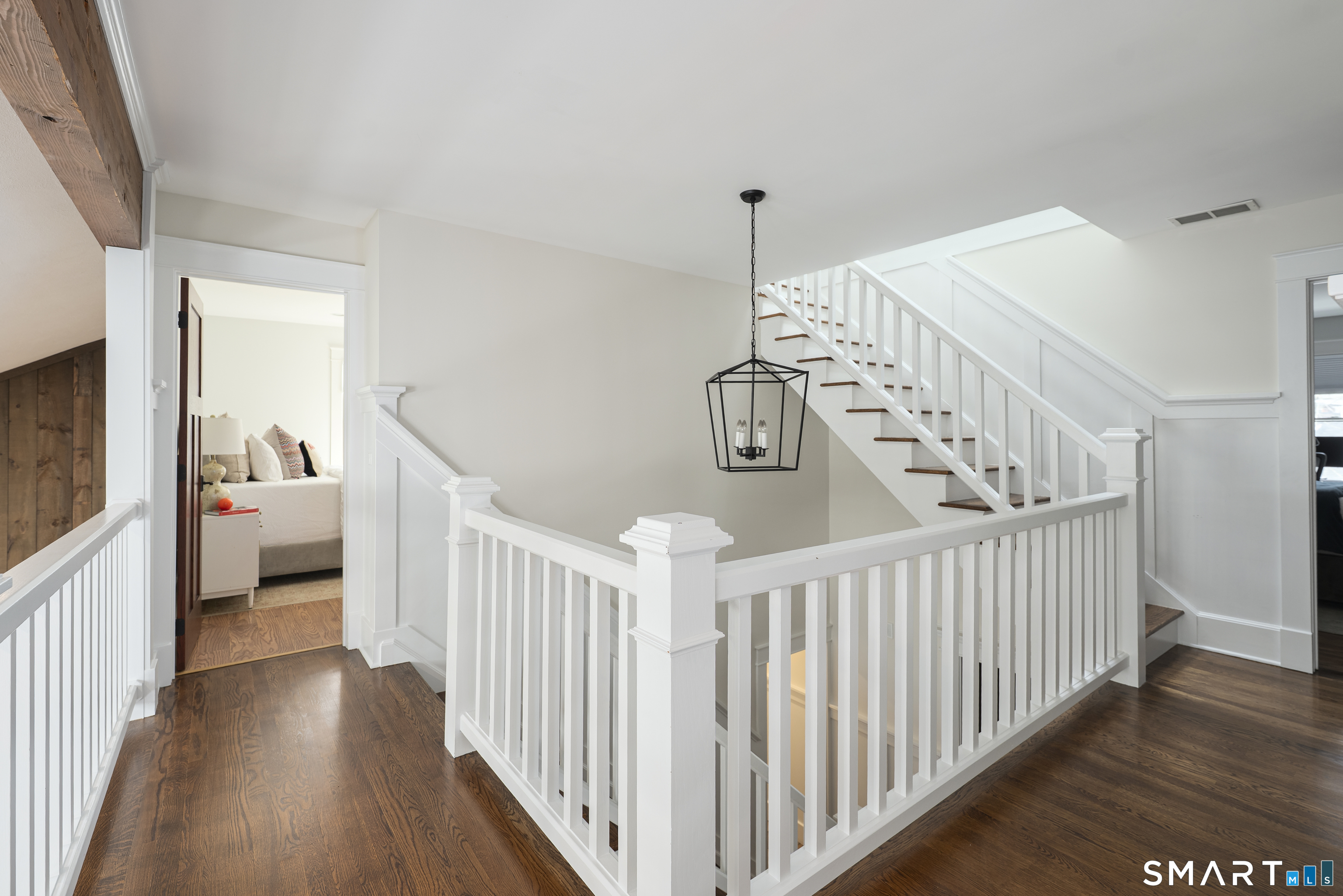 107 Parade Hill Road New Canaan, CT 06840 - Photo 12 of 28 a view of a hallway to a livingroom with wooden floor and stairs