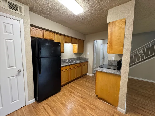 a kitchen with a refrigerator and a stove top oven
