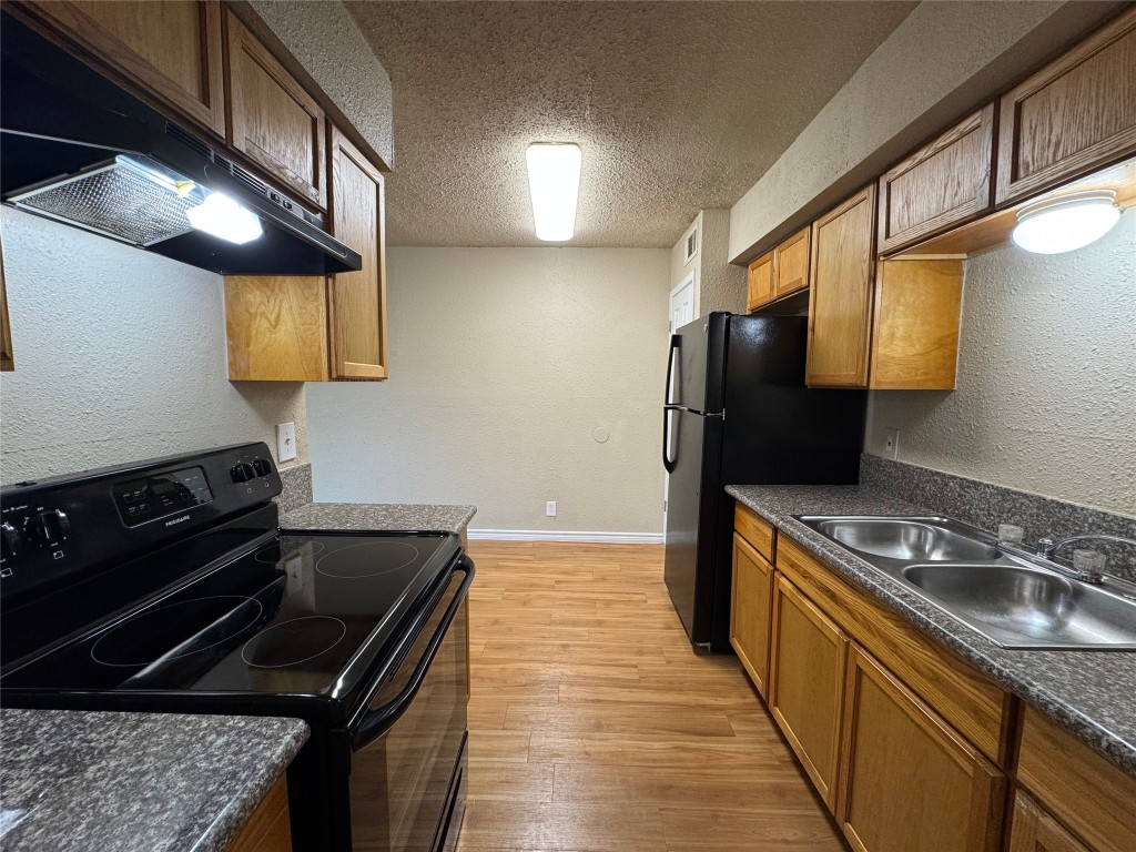4904 West Wind Trail, Unit 101 Austin, TX 78745 - Photo 6 of 18 a kitchen with a stove a sink and a refrigerator