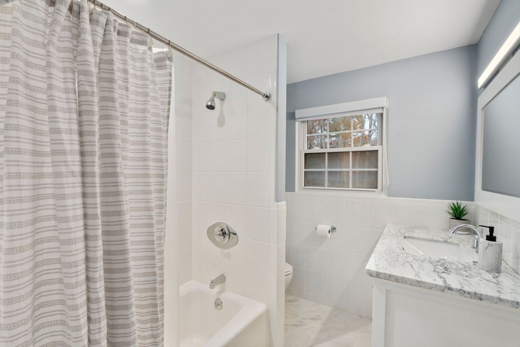 52 Condor Road Sharon, MA 02067 - Photo 25 of 36 a bathroom with a granite countertop sink mirror and a bathtub