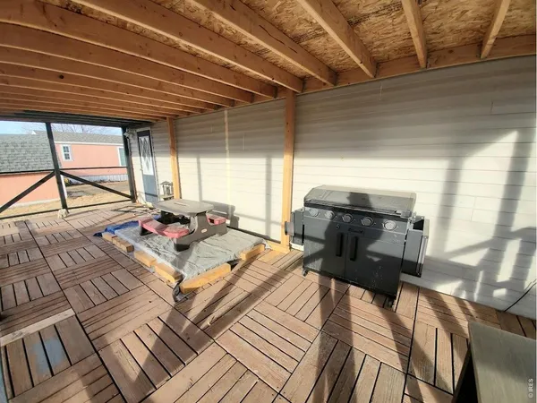 a view of a roof deck with table and chairs with wooden floor