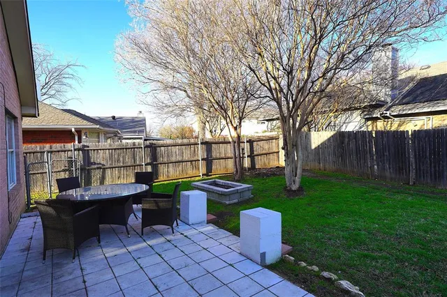 a view of a chairs and table in the backyard