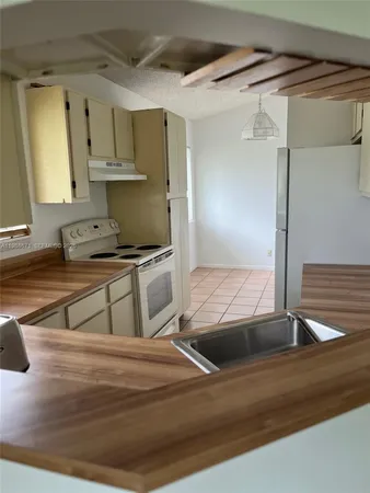 a kitchen with kitchen island granite countertop a sink and a stove