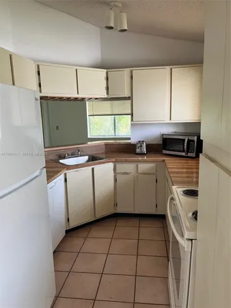 a kitchen with a sink a stove top oven and cabinets