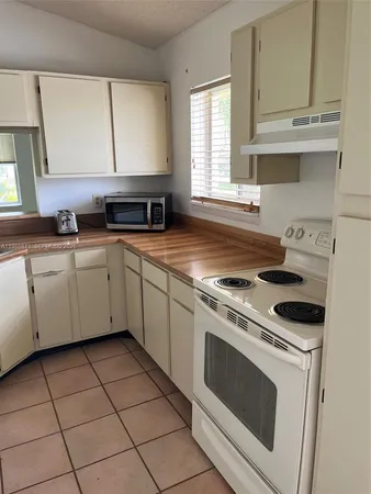 a kitchen with a stove a sink and a window