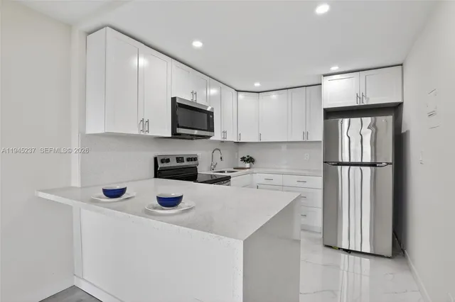a kitchen with a sink a stove a refrigerator and cabinets