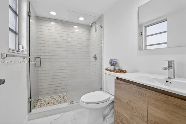 a bathroom with a sink a toilet and shower