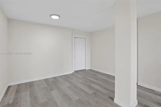a view of an empty room with wooden floor