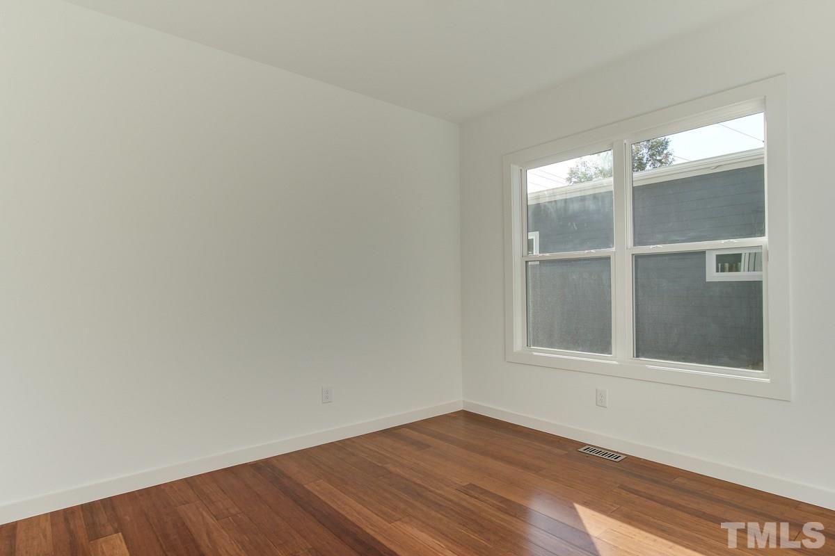 1306 South East Street Raleigh, NC 27601 - Photo 19 of 24 a view of an empty room with wooden floor and a window
