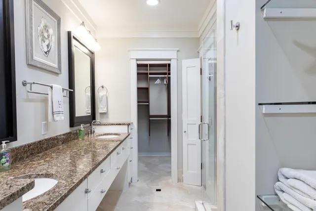a bathroom with a granite countertop tub sink and mirror