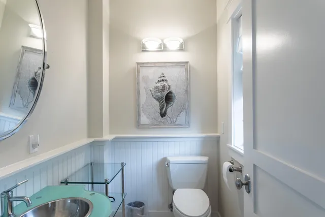 a bathroom with a toilet a sink and mirror