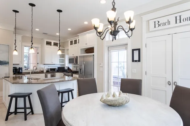 a kitchen with a table chairs and white cabinets