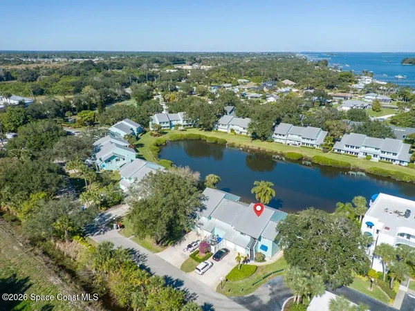 an aerial view of lake and residential houses with outdoor space
