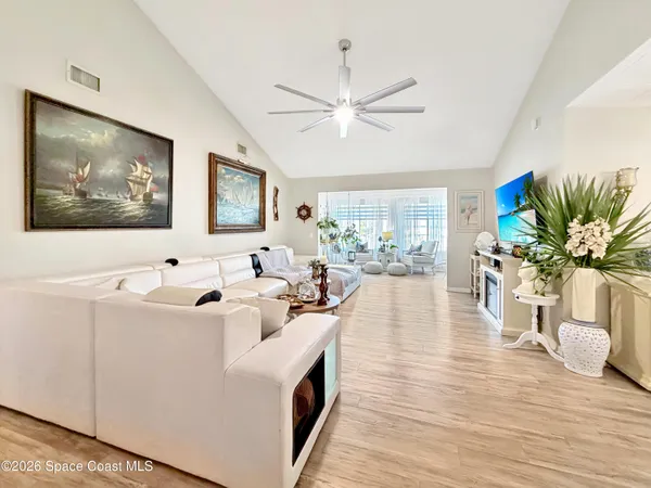 a living room with furniture a fireplace and large windows
