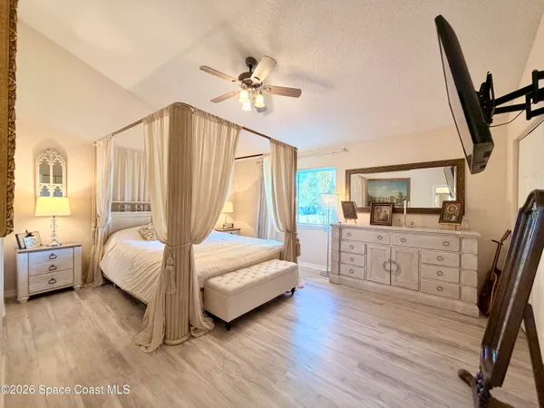 a spacious bedroom with a bed and a chandelier