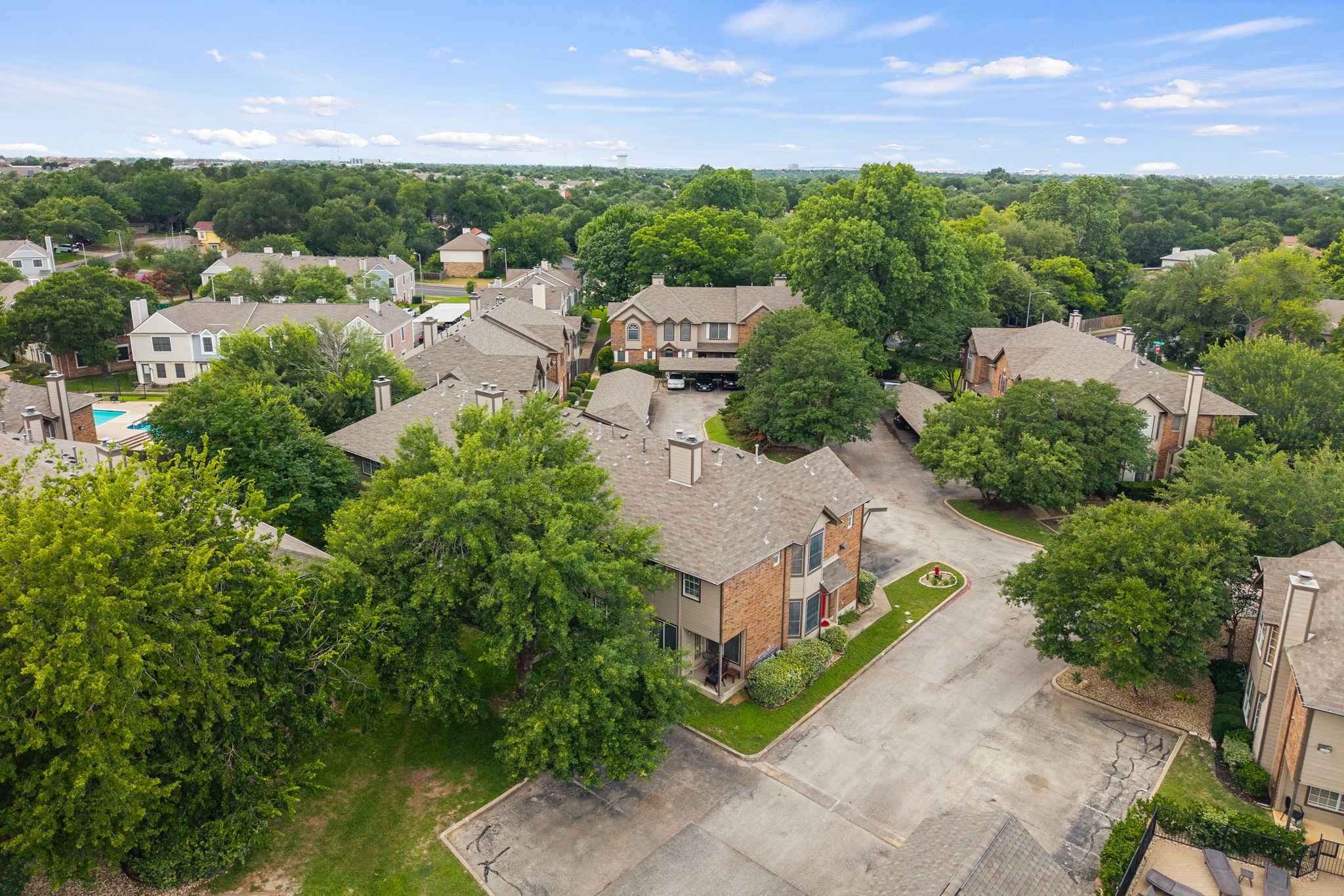 12401 Los Indios Trail, Unit 32 Austin, TX 78729 - Photo 36 of 39 An aerial perspective reveals a charming neighborhood of brick residences nestled among lush, mature trees.