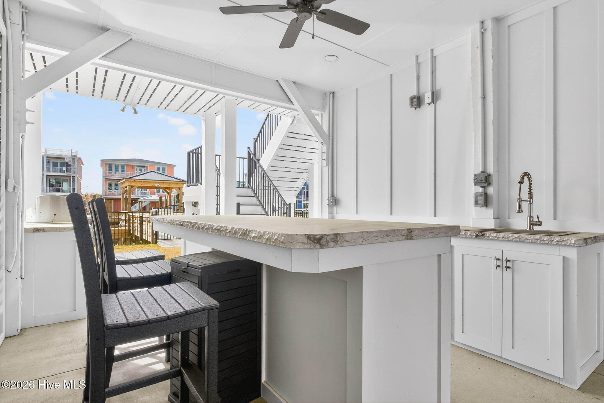1416 Riverside Drive Sunset Beach, NC 28468 - Photo 70 of 83 Outdoor bar area with seating and canal views, blending indoor-outdoor coastal living.