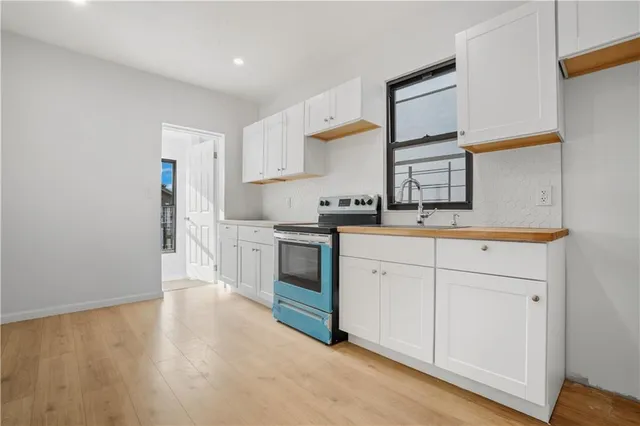 a kitchen with white cabinets and sink