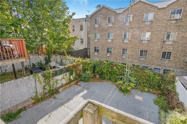 a view of a brick house with a yard and large trees