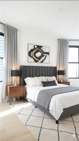 a bedroom with a bed and a couch with large window