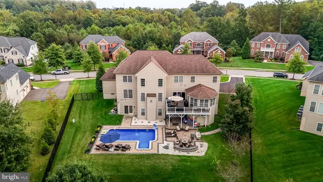 a view of multiple houses with yard and green space