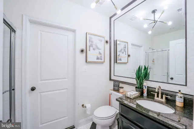 a aerial view of a house with table and chairs under an umbrella next to a yard