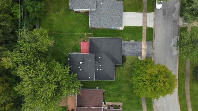an aerial view of a house with yard and seating space