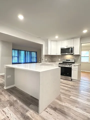 a kitchen with granite countertop a stove top oven and cabinets
