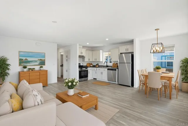 a living room with furniture white walls and kitchen view