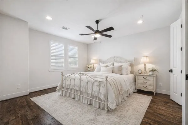 a spacious bedroom with a bed and a chandelier