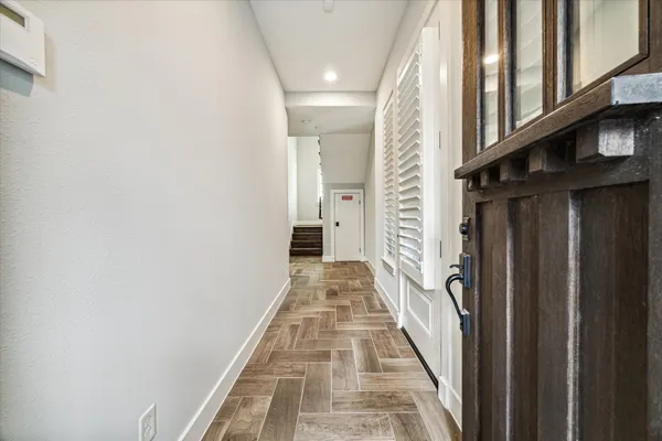 a view of a hallway with wooden floor and staircase