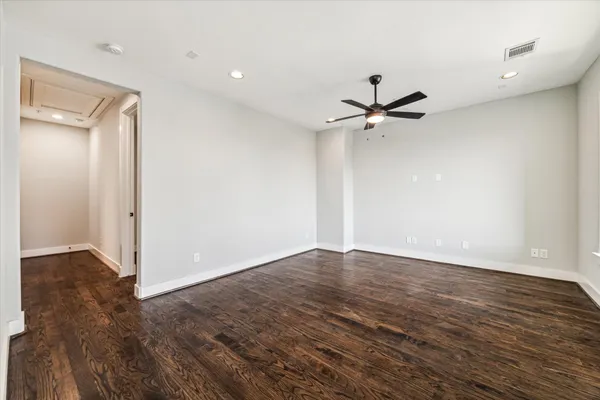 a view of a room with wooden floor and a ceiling fan