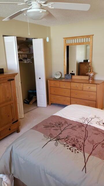 2950 Southeast Ocean Boulevard, Unit 1317 Stuart, FL 34996 - Photo 12 of 19 a bedroom with a bed a mirror and dresser