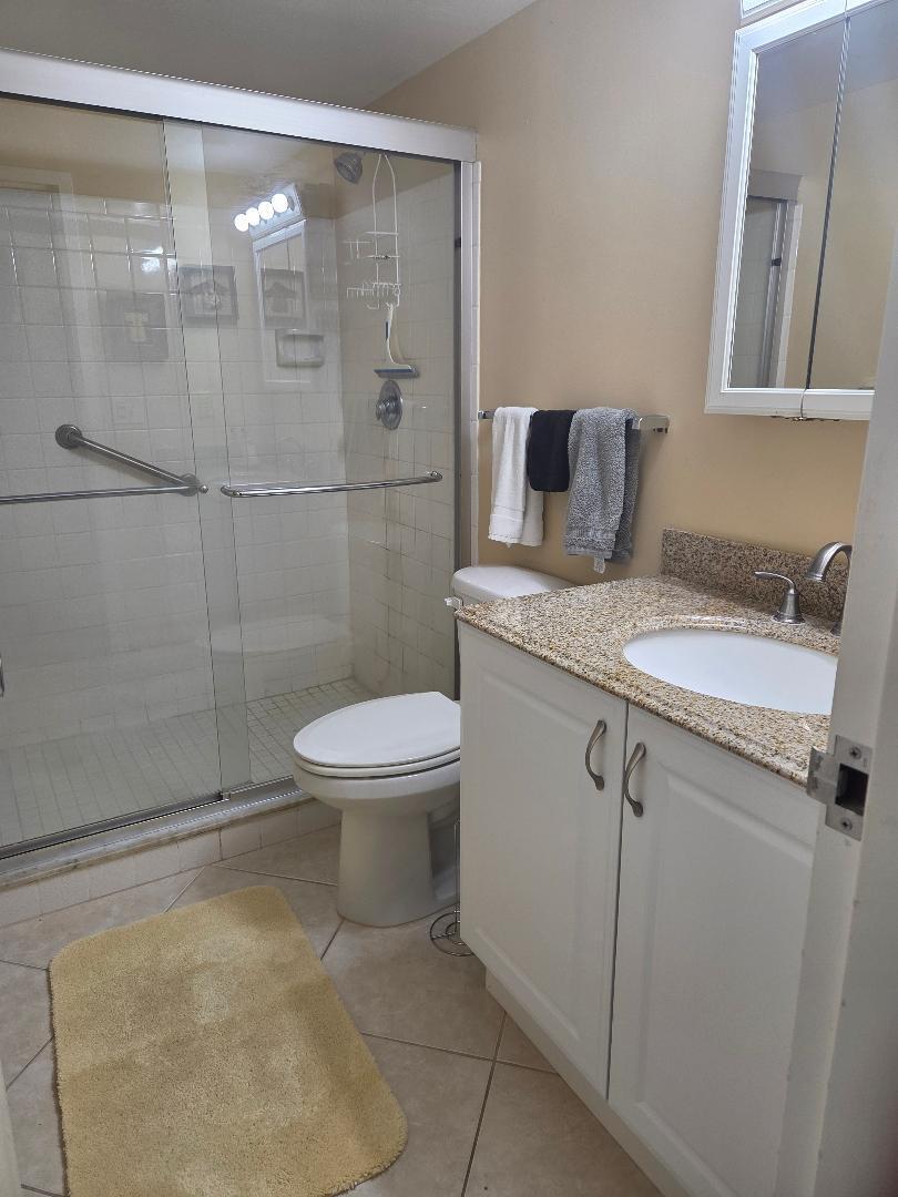 2950 Southeast Ocean Boulevard, Unit 1317 Stuart, FL 34996 - Photo 13 of 19 a bathroom with a granite countertop sink toilet and shower